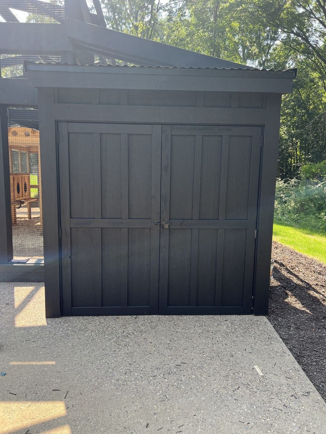 Custom black board-and-batten shed doors with forged hardware